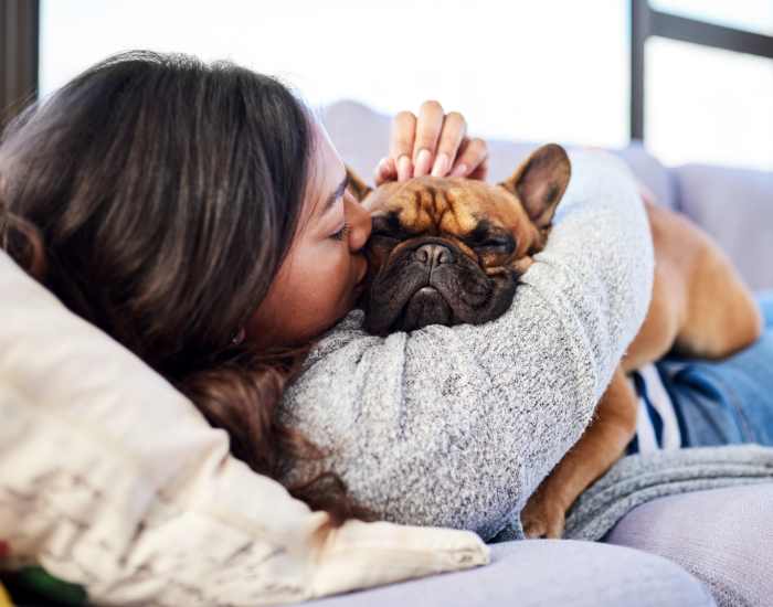 Woman laying on a couch along with her dog in living room at Ventana Hills in Coraopolis, Pennsylvania