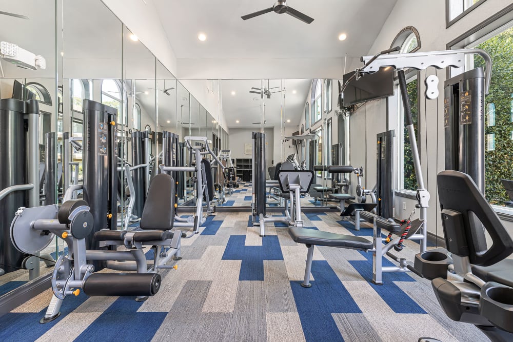 Exercise bikes in fitness room overlooking pool at Marquis at Kingwood in Kingwood, Texas