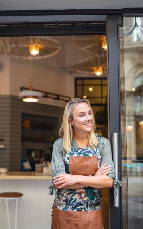 Shop keeper standing in their doorway near Instrata at Legacy West in Plano, Texas