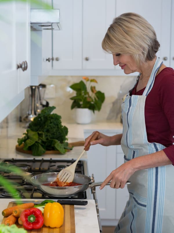 Resident cooking a meal at The Galleria in Fountain Valley, California