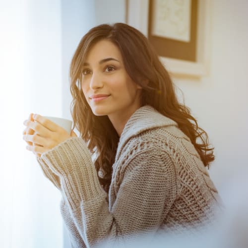 A resident relaxing and drinking out of a mug in a home at Silver Strand I in Coronado, California