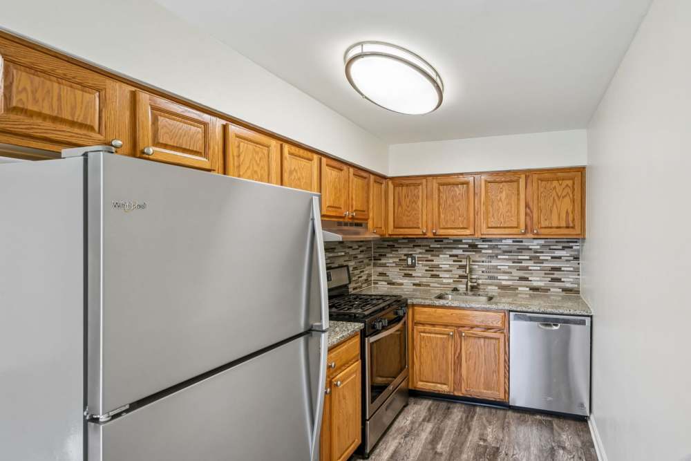 Kitchen with white appliances and tile backsplash at Chesterfield Apartment Homes in Levittown, Pennsylvania