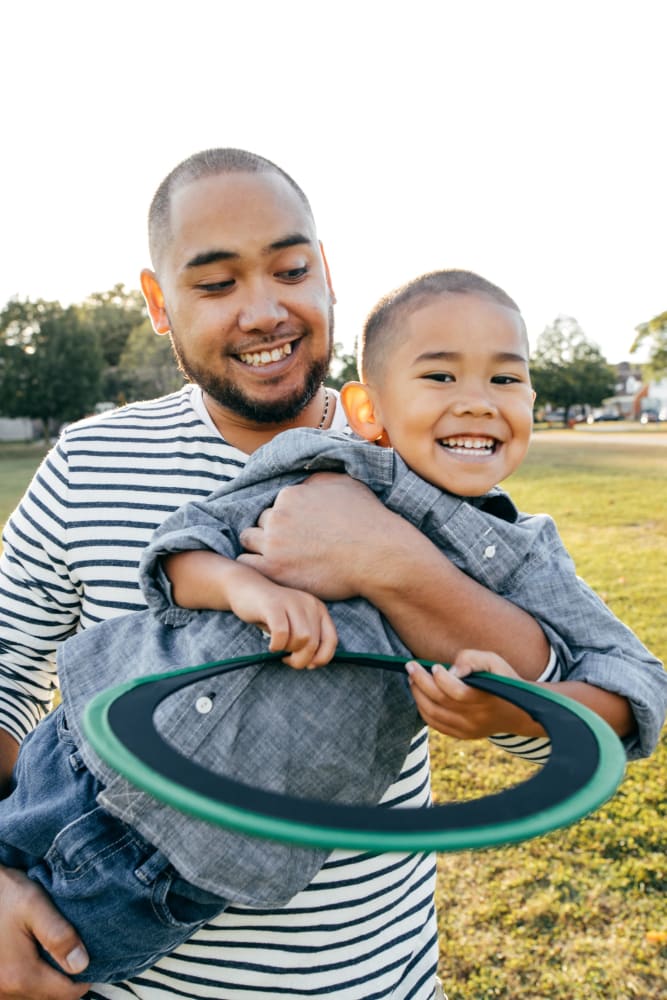 Father and son playing in the park near their home at Elmwood Village Apartments & Townhomes in Elmwood Park, New Jersey