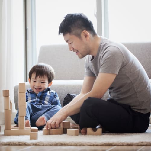 A father playing with his son in a livingroom at Hamilton Redoubt in Newport News, Virginia