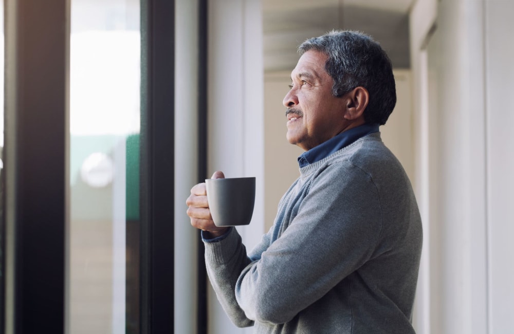 Resident drinking coffee and looking out the window at Laguna Senior in Los Angeles, California