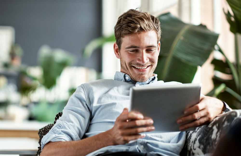 Resident reading on his tablet in his serene apartment home at La Espana Garden in Lodi, California