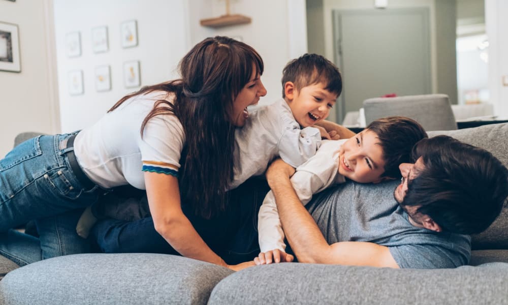 Family laying on the couch in their new home at Verandas at Alamo Ranch in San Antonio, Texas