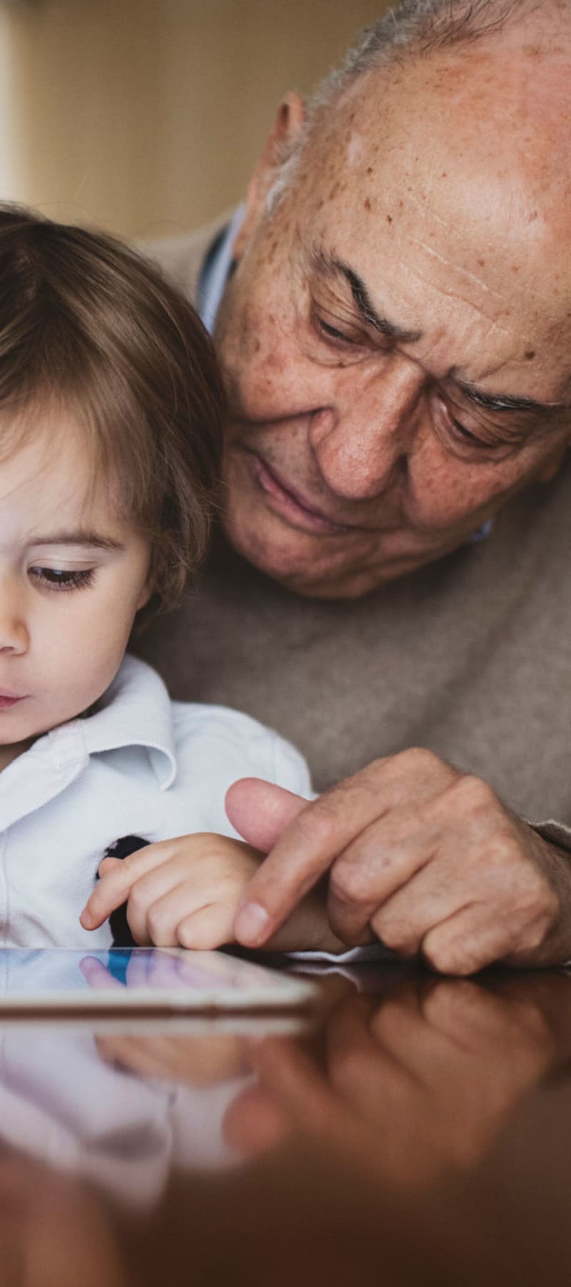 Resident playing with grandchild on an ipad at Wellington Meadows in Fort Atkinson, Wisconsin