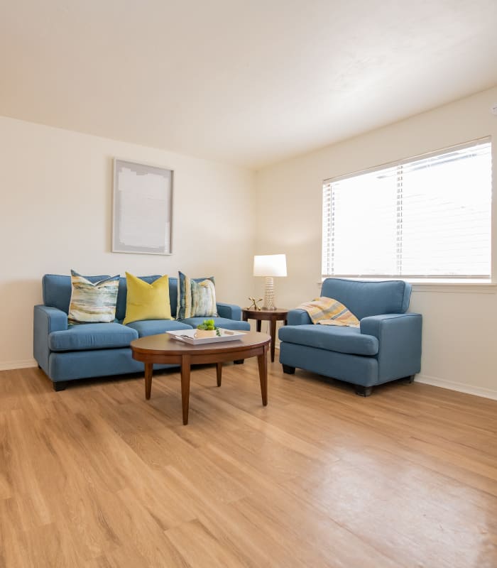 Couches on wood style flooring in a living room at Apple Creek Apartments in Stillwater, Oklahoma