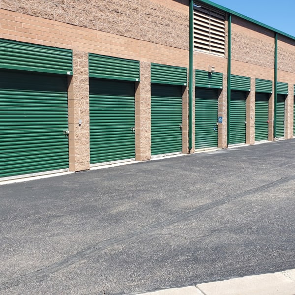 Outdoor storage units with green doors at StorQuest Self Storage in Aurora, Colorado