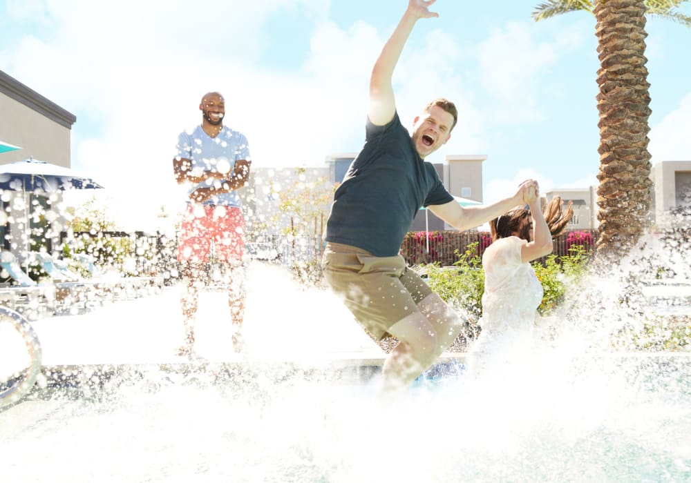 Friends splashing water in pool at BB Living at Val Vista in Gilbert, Arizona