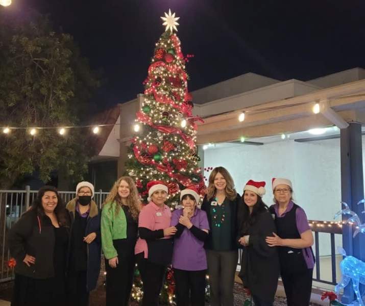 The Montera staff and residents posing for a group photo in front of a Christmas tree