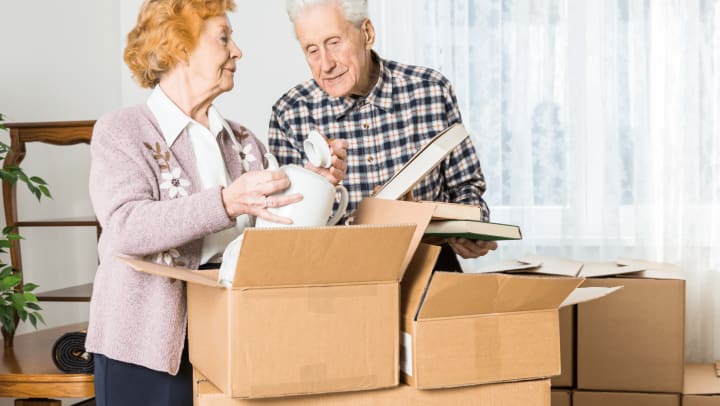 Two elderly people packing moving boxes