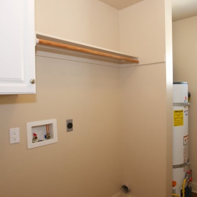 A laundry area with washer and dryer hookups and storage at San Onofre II in San Clemente, California