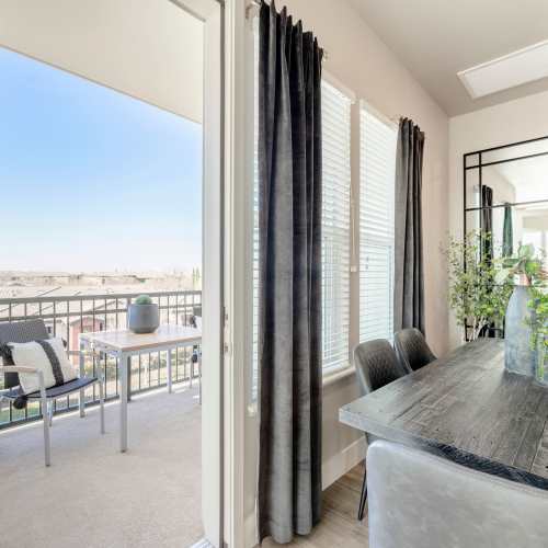 Large dining table and door to balcony at Alira Apartments in Sacramento, California