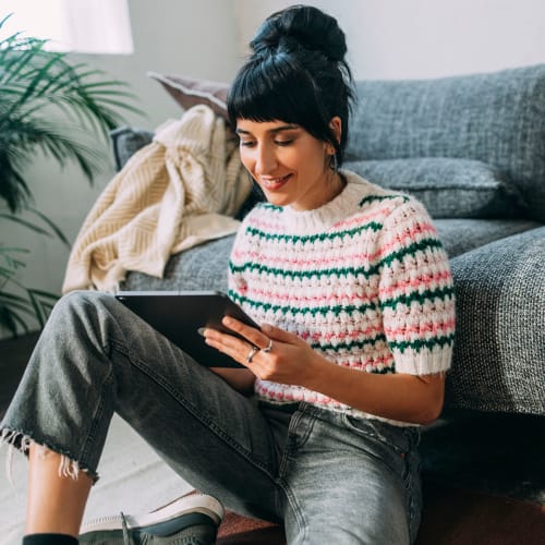 A resident looking enjoying some screen time on her device at Aster, Long Beach, California