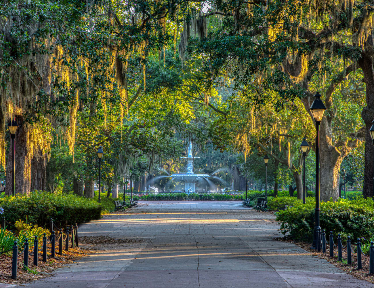 Beautiful canopy of mature trees shading the pathway to a park's fountain near The Bentley at Marietta in Marietta, Georgia