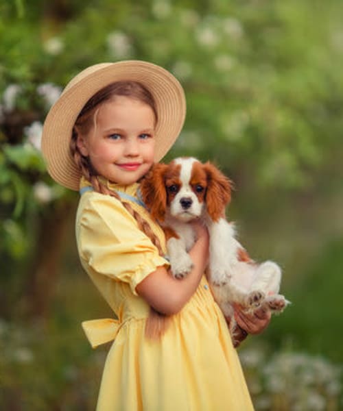Child holding their Cavalier King Charles Spaniel at Chelsea at Lee Hall in Newport News, Virginia