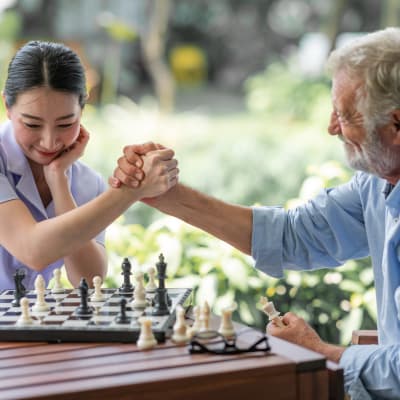 Resident and caregiver playing chess at The Sanctuary at West St. Paul in West St. Paul, Minnesota