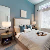 Modern furnishings in a model apartment's primary bedroom at Cornell Midtown in Dallas, Texas