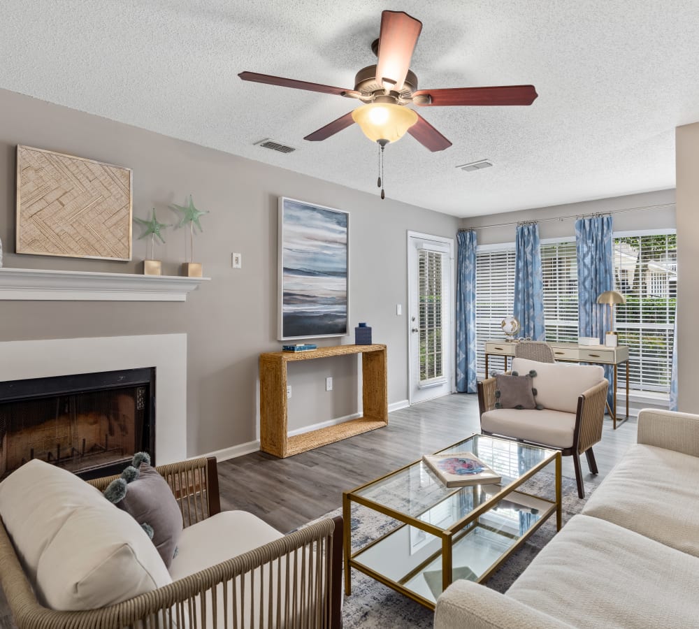 A spacious living room with a fireplace and balcony access at Gates at Jubilee in Daphne, Alabama