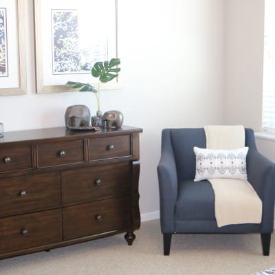 Memory care bedroom suite with chair and dresser at The Sanctuary at Brooklyn Center in Brooklyn Center, Minnesota