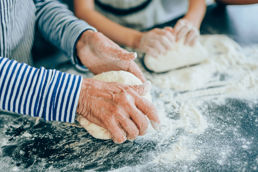 Resident kneading dough with a younger family member at Senior Commons at Powder Mill in York, Pennsylvania