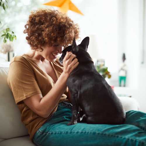 Resident cuddling with her dog in their living room at Home Suites Apartments in Sparks, Nevada