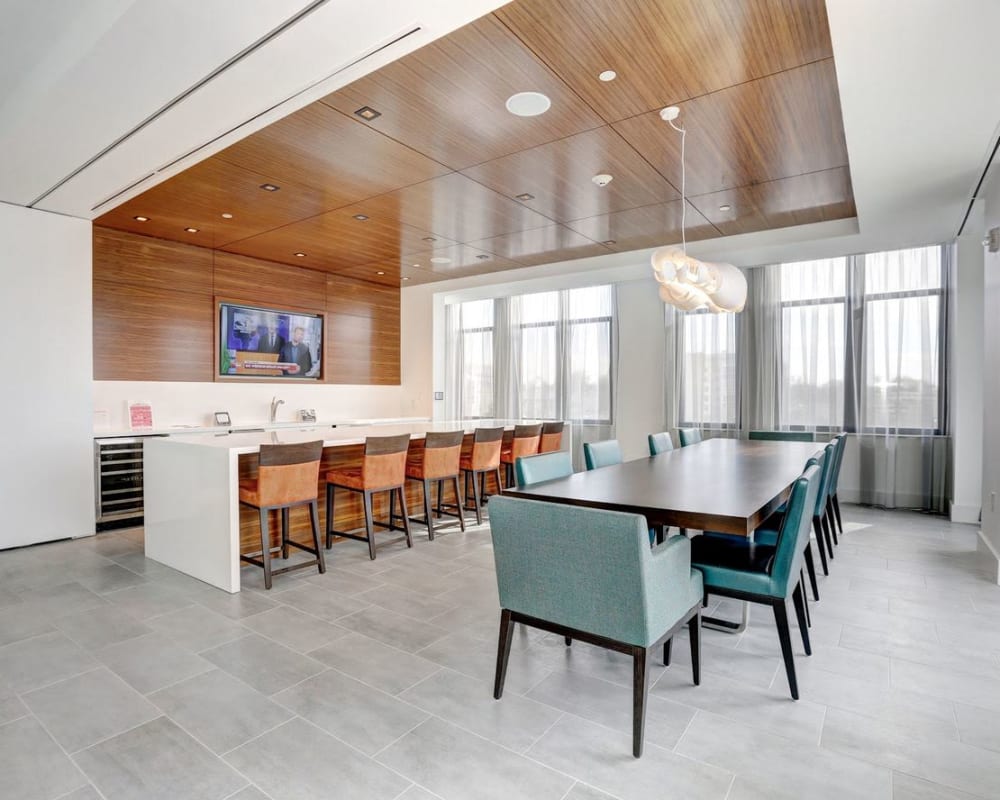 Rustic clubhouse with bar seating, flat-screen TVs and a fireplace at Solaire 7077 Woodmont in Bethesda, Maryland