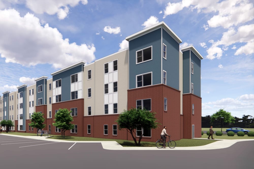 Modern apartment community with vibrant exterior, landscaped greenery, and residents walking and biking at Galloway Crossing in Charlotte, North Carolina