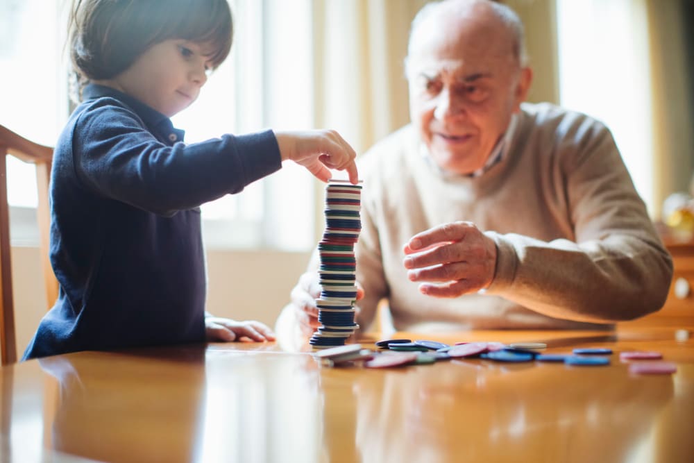 An elderly gentleman stacking tiles with a child at Concord Place in Concord, North Carolina