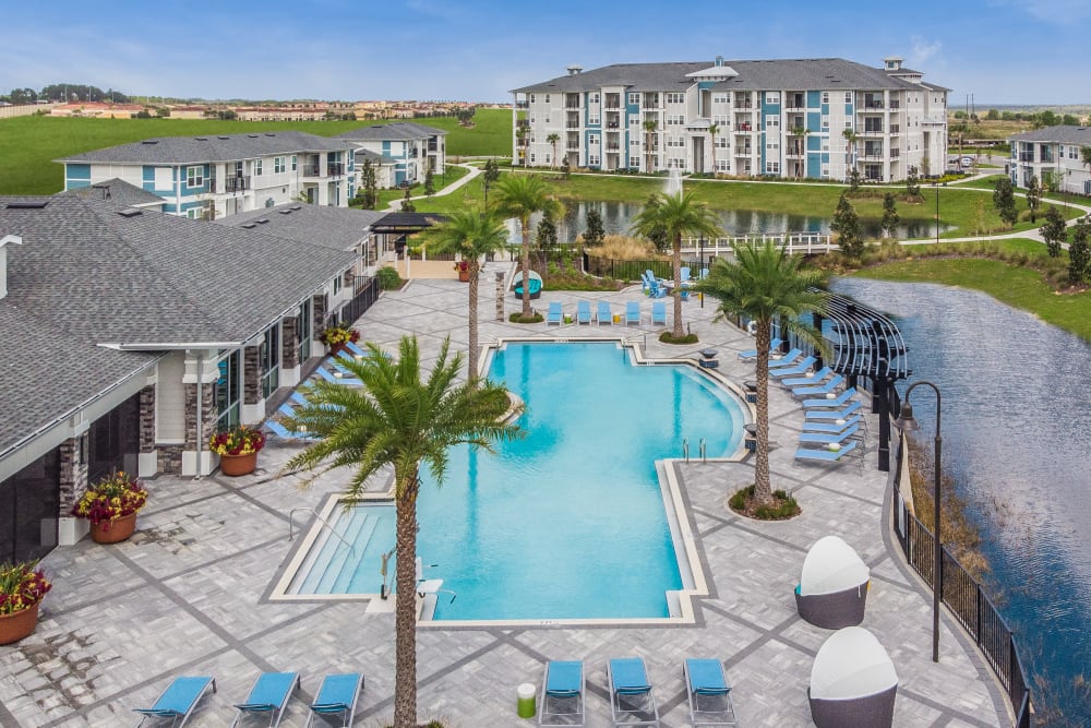Aerial view of the pool and lake at Champions Vue Apartments in Davenport, Florida