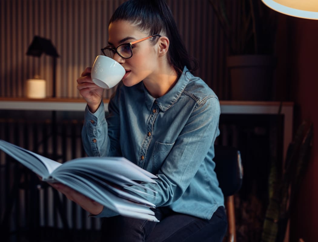 Resident drinking coffee and reading at The Remington Apartments in Wichita, Kansas