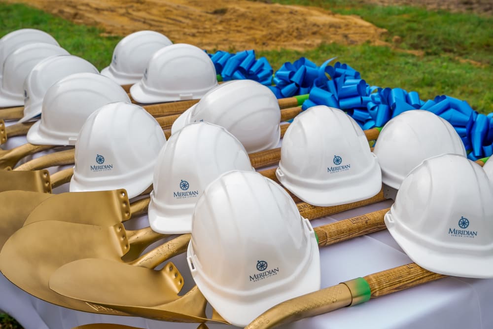 Close up of White hard hats with gold shovels