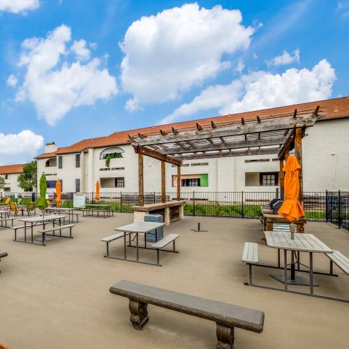 Covered tables and chairs by the pool at Villas de Toscana in San Antonio, Texas