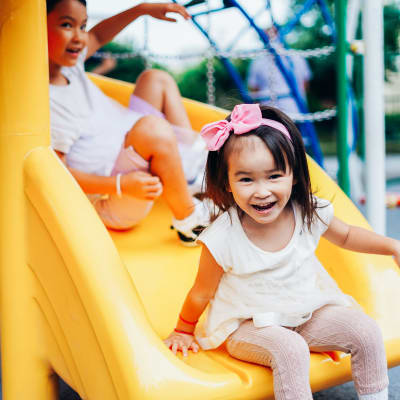 Two small children going down a park slide near Fountain City in Columbus, Georgia