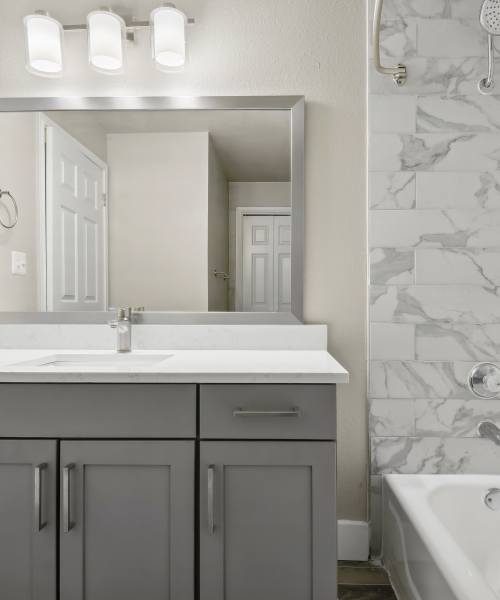 Modern bathroom with mirror, sink and bathtub at Charleston in San Antonio,Texas