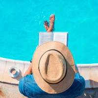 A man reading on the edge of the swimming pool at Retreat at Fairhope Village in Fairhope, Alabama