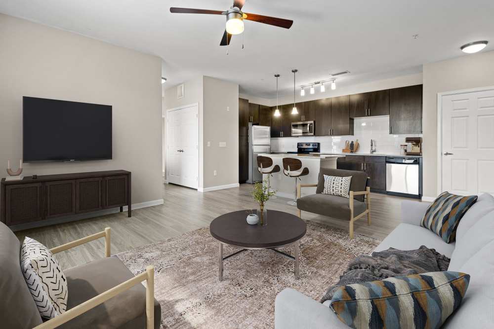 Spacious living room and updated kitchen with espresso cabinets at The Parc at Greenwood Village in Greenwood Village, Colorado