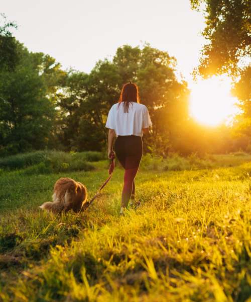 Resident walking her dog in a park near Citrus Run Apartments in Tampa, Florida