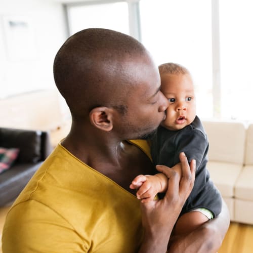 A father holding his son at Dahlgren Townhomes in Dahlgren, Virginia