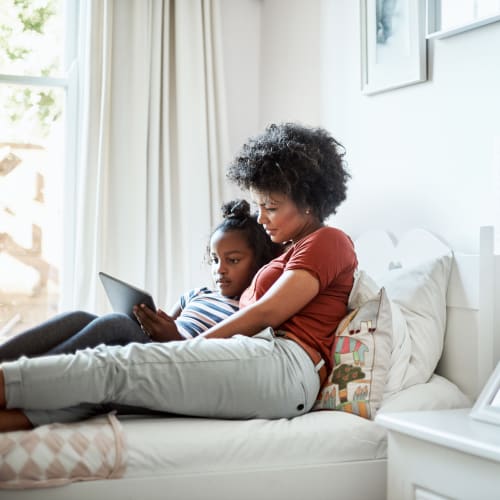 A mother and her daughter holding and watching movie on iPad at Castle Acres in Norfolk, Virginia