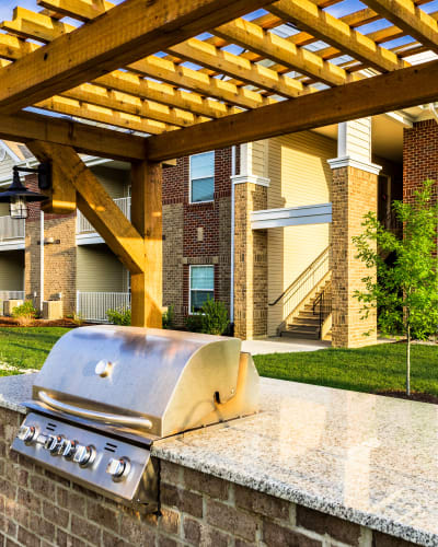 Gas BBQ grill with spacious stone countertop underneath pergola at Valley Farms in Louisville, Kentucky