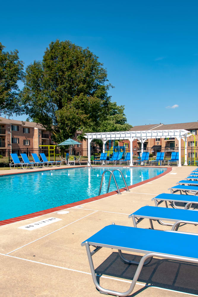 Swimming pool surrounded by lounge chairs at Chesterfield Apartment Homes in Levittown, Pennsylvania