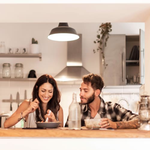 A couple having a meal in kitchen at Castle Acres in Norfolk, Virginia