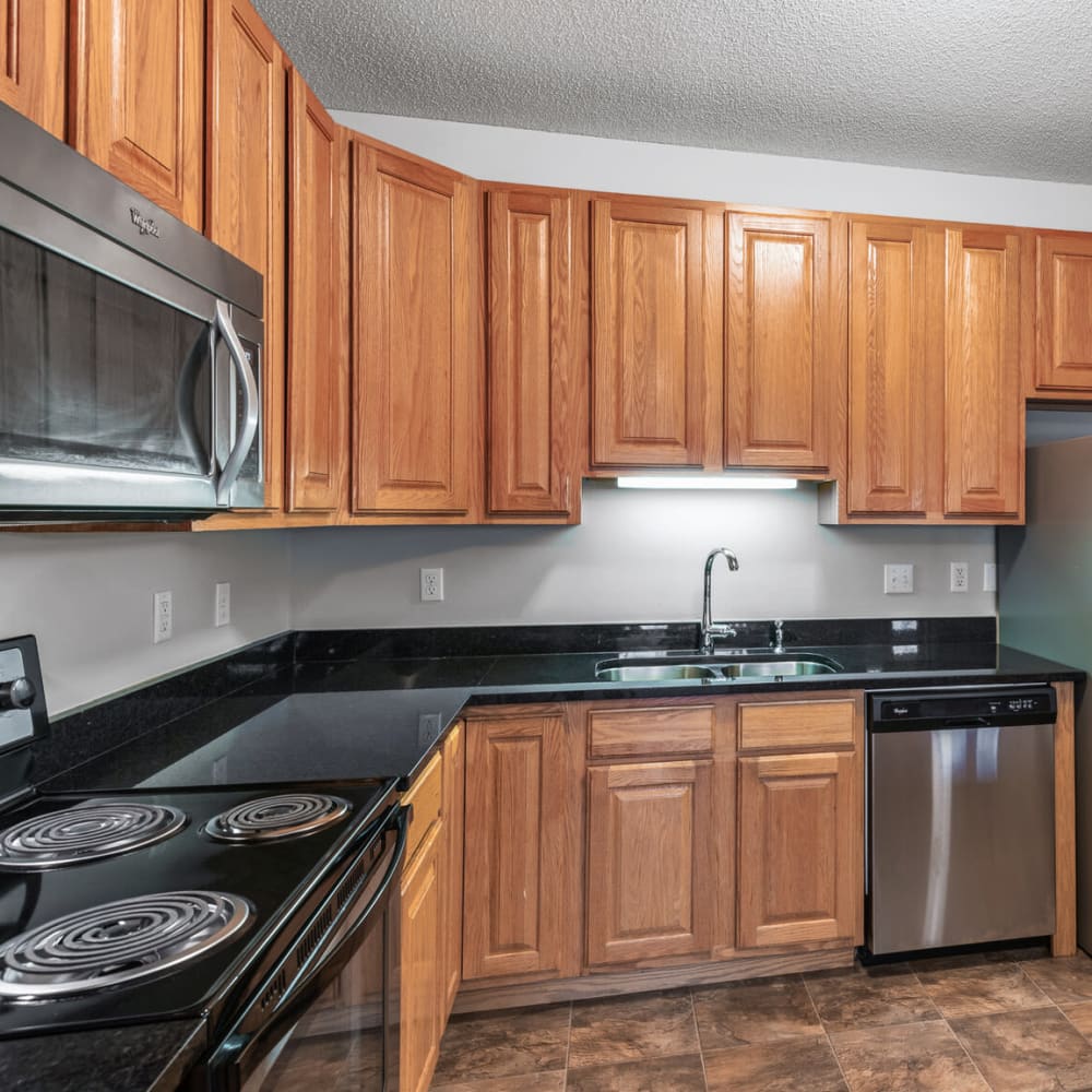  Wood cabinetry and hardwood flooring in a model townhome's kitchen at Oaks Lincoln Apartments & Townhomes in Edina, Minnesota