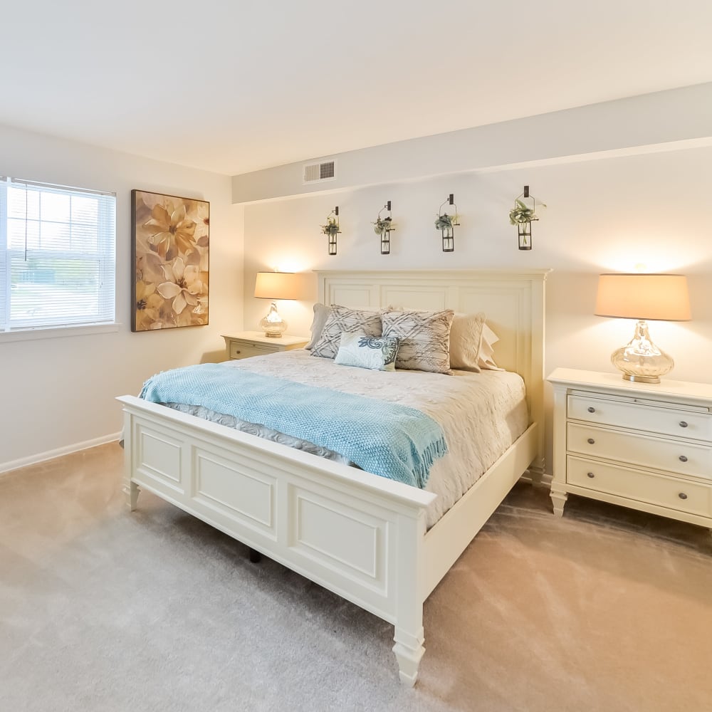 A cozy bedroom with wall-to-wall carpeting in a home at Eastampton Gardens Apartment Homes in Eastampton, New Jersey
