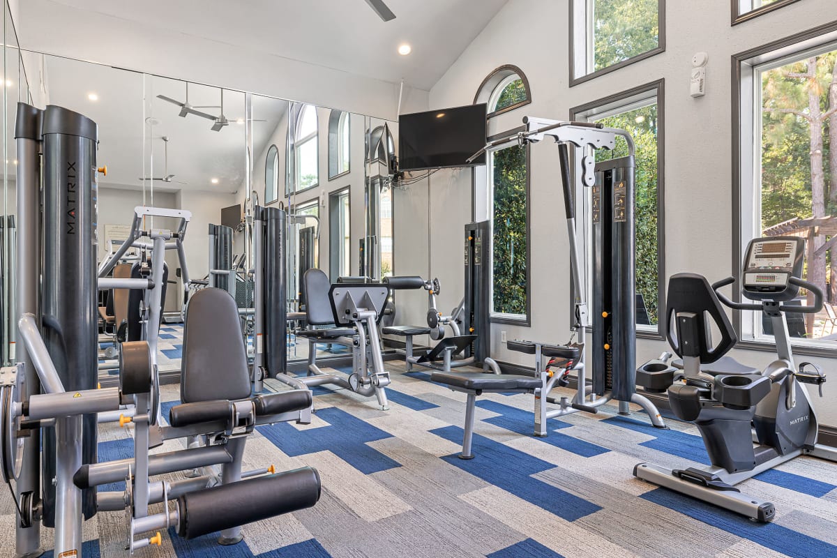Exercise bikes in fitness room overlooking pool at Marquis at Kingwood in Kingwood, Texas
