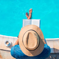 A man sitting with his feet in the swimming pool at The Alexandria in Madison, Alabama