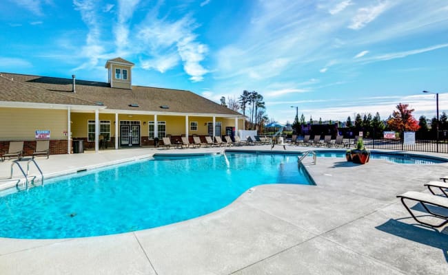 Swimming pool with a sundeck and lounge chairs at Carden Place Apartment Homes in Mebane, North Carolina